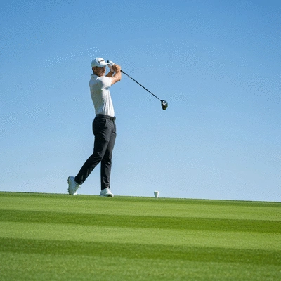 Golfer mid-swing with a modern golf driver on a pristine green course, clear sky, action shot, no text, no words, no typography, clean image